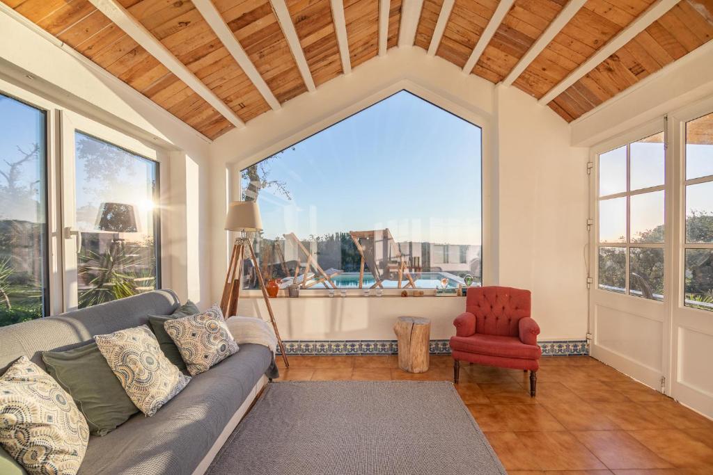 a living room with a couch and a red chair at CASAVADIA melides in Melides