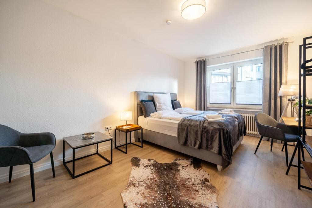a bedroom with a bed and a window and a couch at Cityapartment Wagner mit Netlix in Bielefeld
