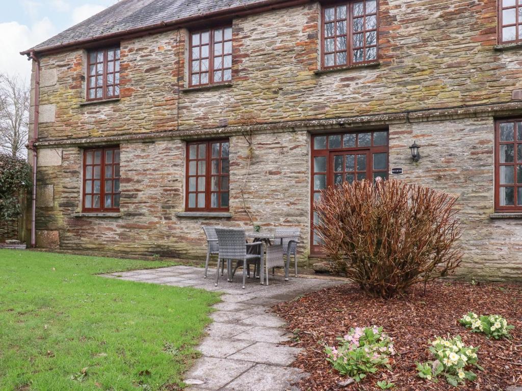 a stone house with a table and chairs in front of it at Roughtor Cottage in Bodmin