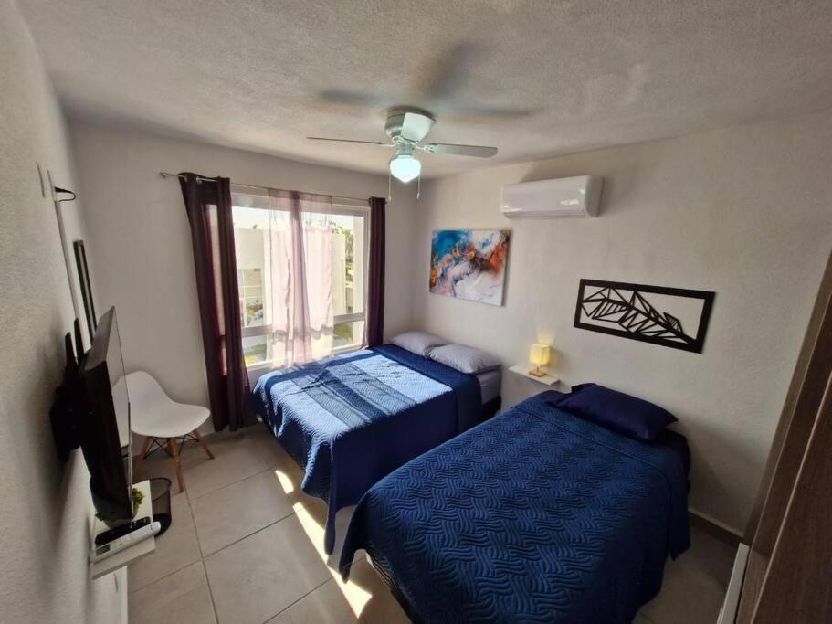 1 dormitorio con 2 camas y ventana en Depto. con club de Playa, en Acapulco