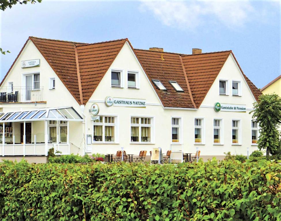 un grande edificio bianco con tetto marrone di Gasthaus & Pension Natzke a Usedom Town