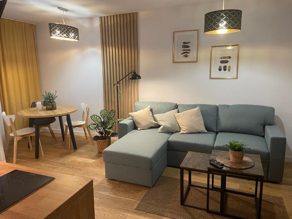 a living room with a blue couch and a table at PM RESIDENCE KORFANTEGO 8 in Katowice