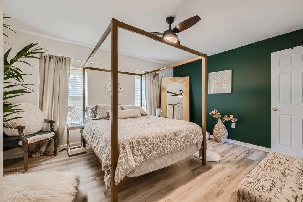 Baltimore Beauty! Johns Hopkins! 3 bedroom apt في بالتيمور: غرفة نوم بسرير مظلة وجدران خضراء