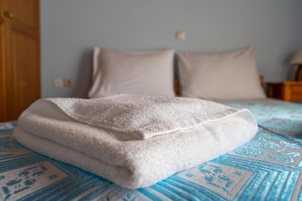 a white blanket sitting on top of a bed at Ocean Breeze Apartment in Kypseli