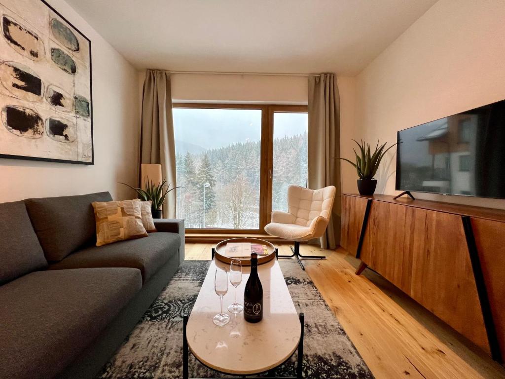 a living room with a couch and a tv at Golden Ridge Apartments in Špindlerův Mlýn