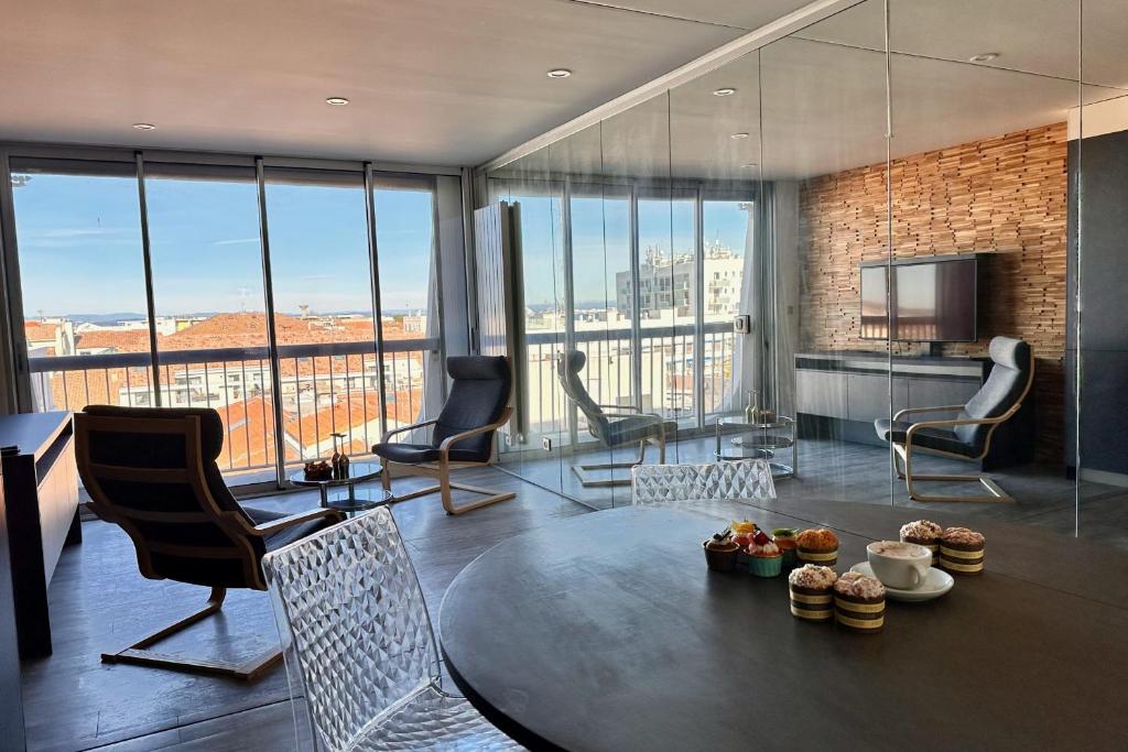 un salon avec une table et des chaises dans un immeuble dans l'établissement LES PIEDS DANS L'EAU - Magnifique P2 proche de la mer, au Grau-du-Roi