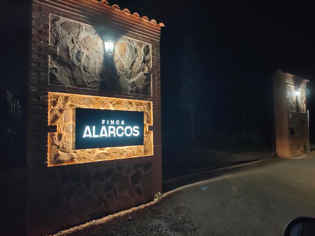una señal en el lateral de un edificio por la noche en Finca Alarcos en Valverde