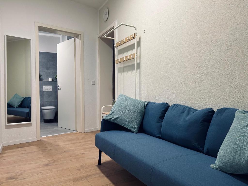 um sofá azul num quarto com casa de banho em 2 Schlafzimmer-Balkon-Küche-Parkplatz-Designerbad em Leipzig