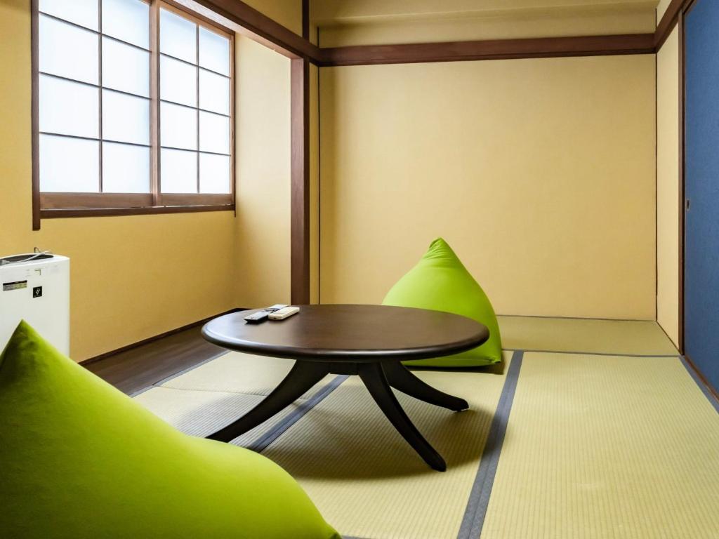 Habitación con mesa y sillas verdes en HOTEL MARINEPIA - Vacation STAY 92243v en Shinkamigoto