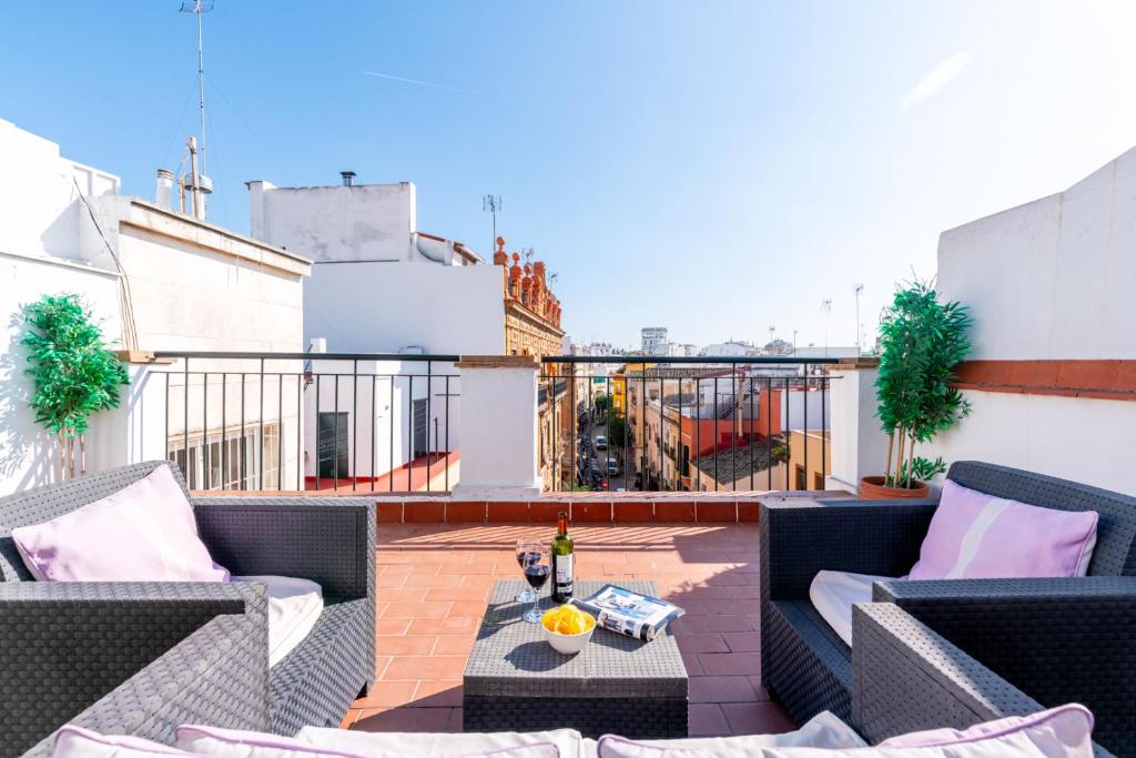 a patio with chairs and a table on a roof at AtGr Luminoso Ático con Terraza, Calle Antonia Diaz in Seville