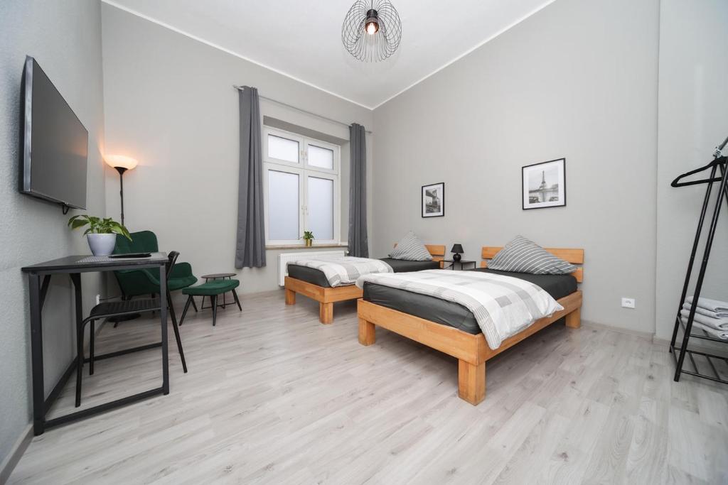 ein Schlafzimmer mit zwei Betten und einem Schreibtisch und einem Tisch in der Unterkunft Apartment Central 85B 40qm Wi-Fi free in Dortmund