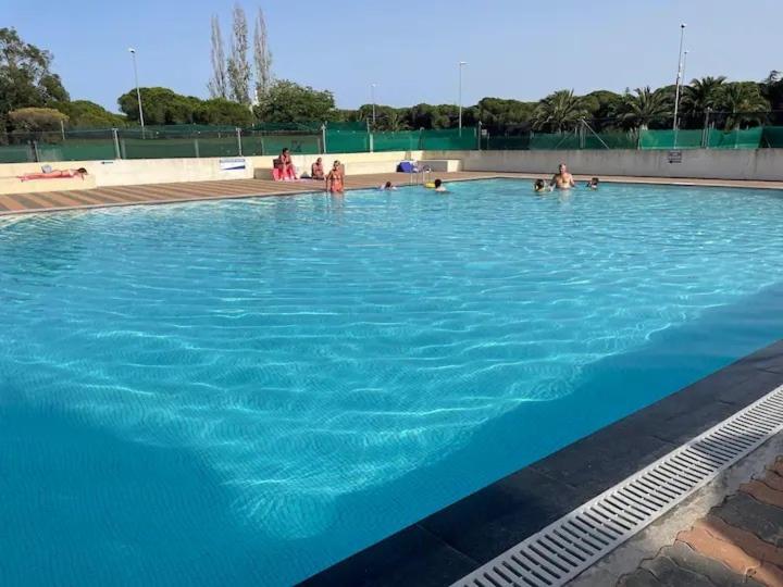 une grande piscine bleue avec des gens dedans dans l'établissement Tennis Village avec terrasse, piscine, clim et parking, au Cap d'Agde