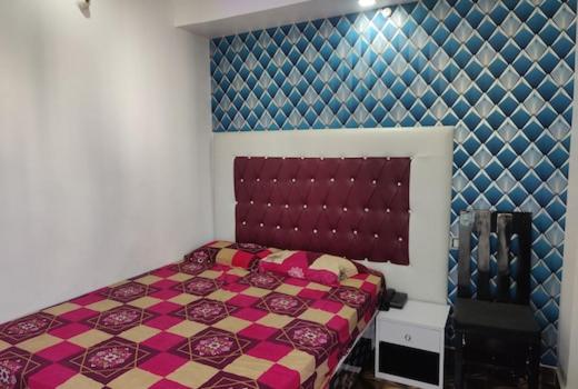 a bedroom with a bed with a checkeredkered wall at Hotel Shivaay Inn in Patna