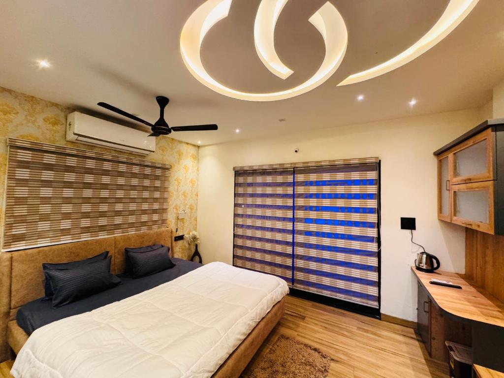 a bedroom with a bed and a ceiling fan at Home Escape Luxe 2BHK Penthouse Near LIG Square in Indore