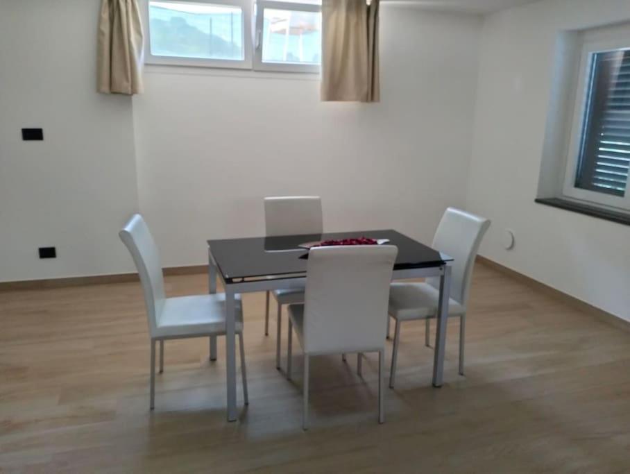 a dining room with a black table and white chairs at Casa Green in Silvi Marina