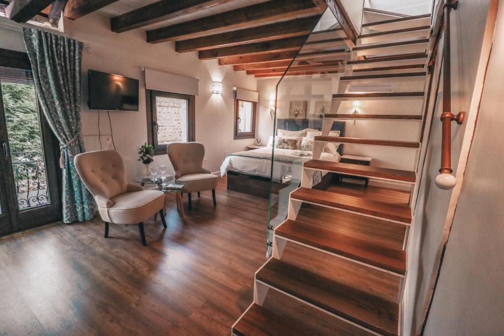 a living room with a staircase and a bedroom at Casa Airosas in Toledo
