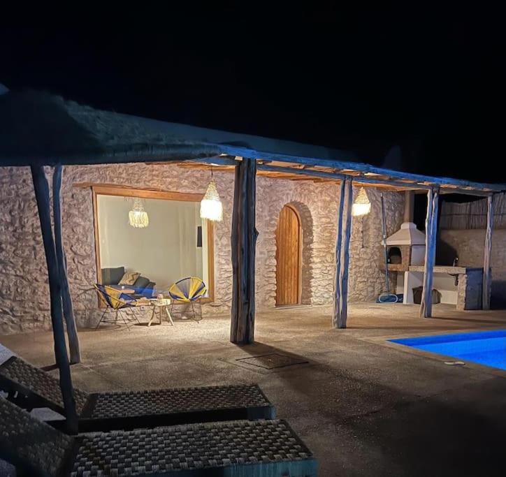 a stone house with a patio at night at Le petit Chalet. in Essaouira