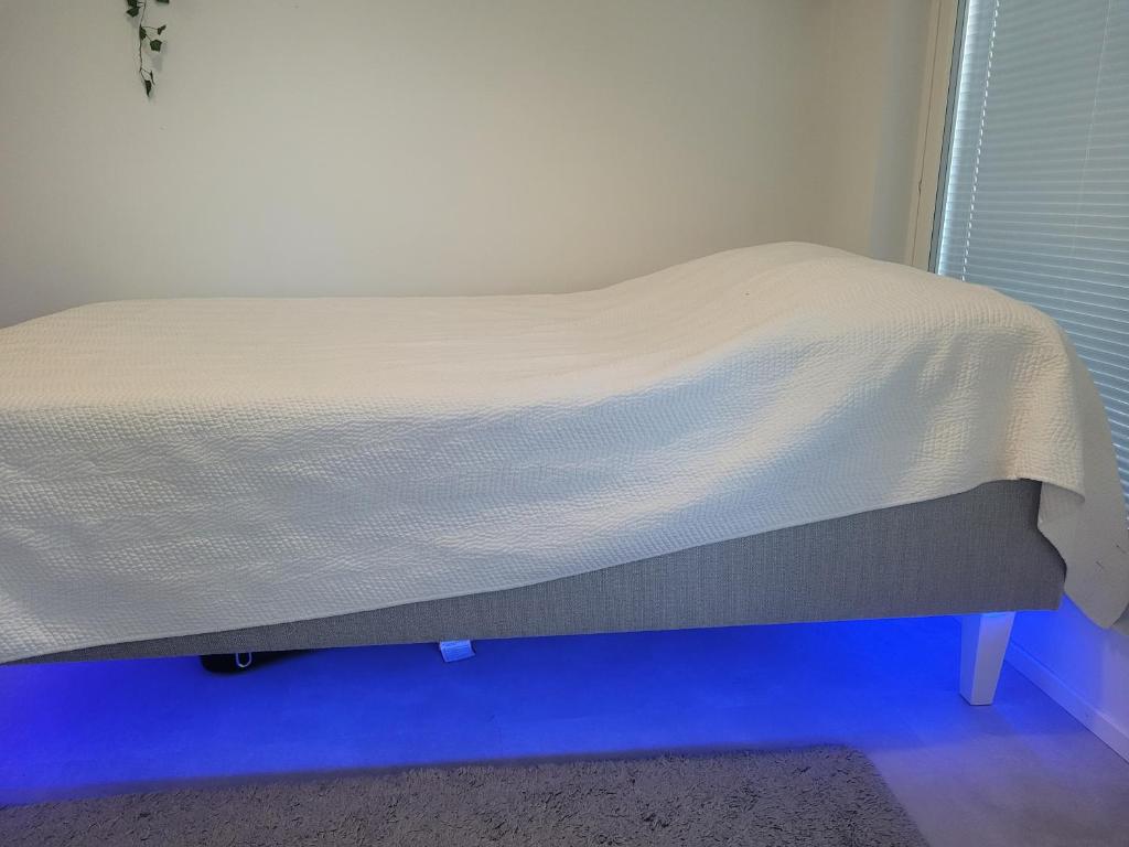 uma cama com uma colcha branca em cima em Loistava sijainti, perfect location. em Vantaa