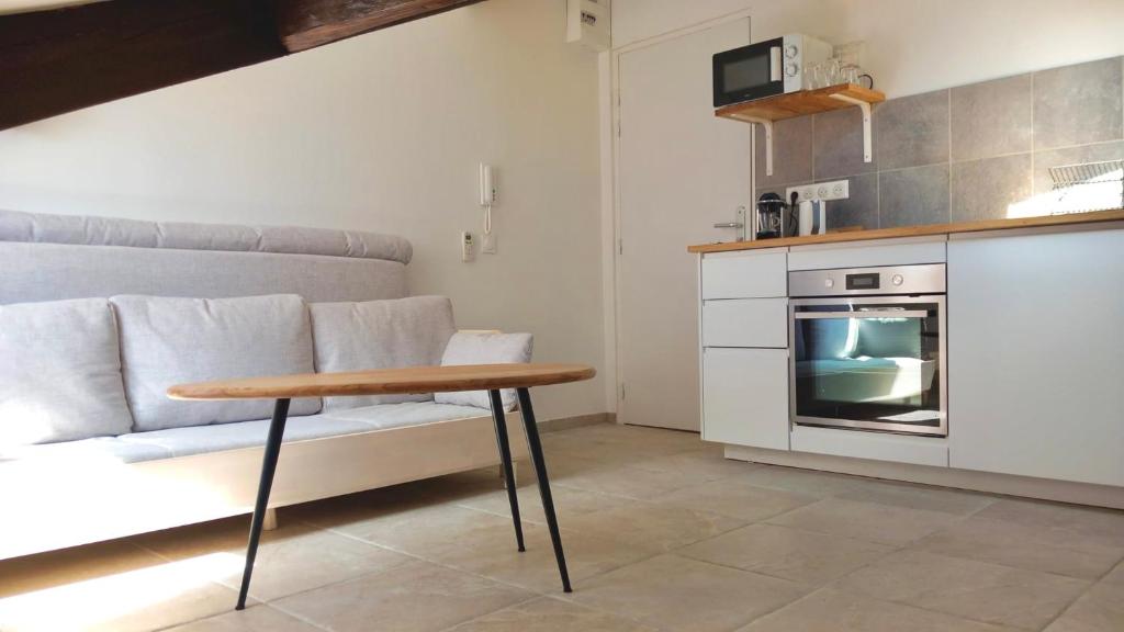 - une cuisine avec un canapé et une table dans une chambre dans l'établissement Petit Studio Cannes - 5min Plages & Gare & Palais des Festivals - Climatisation, à Cannes