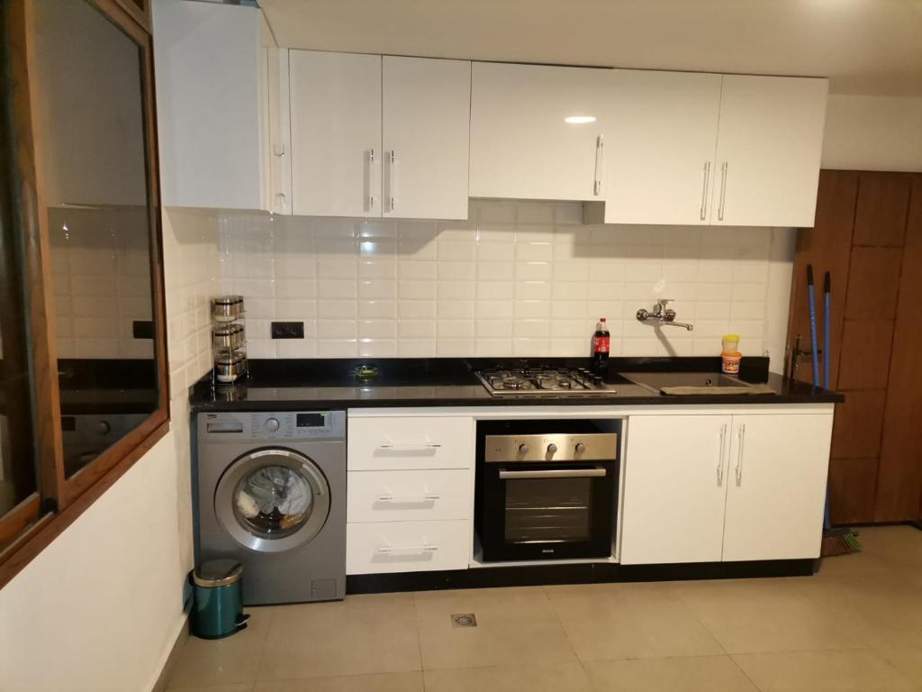 a kitchen with a stove and a washing machine at زاوية سيدي عبد السلام افران in Ifrane