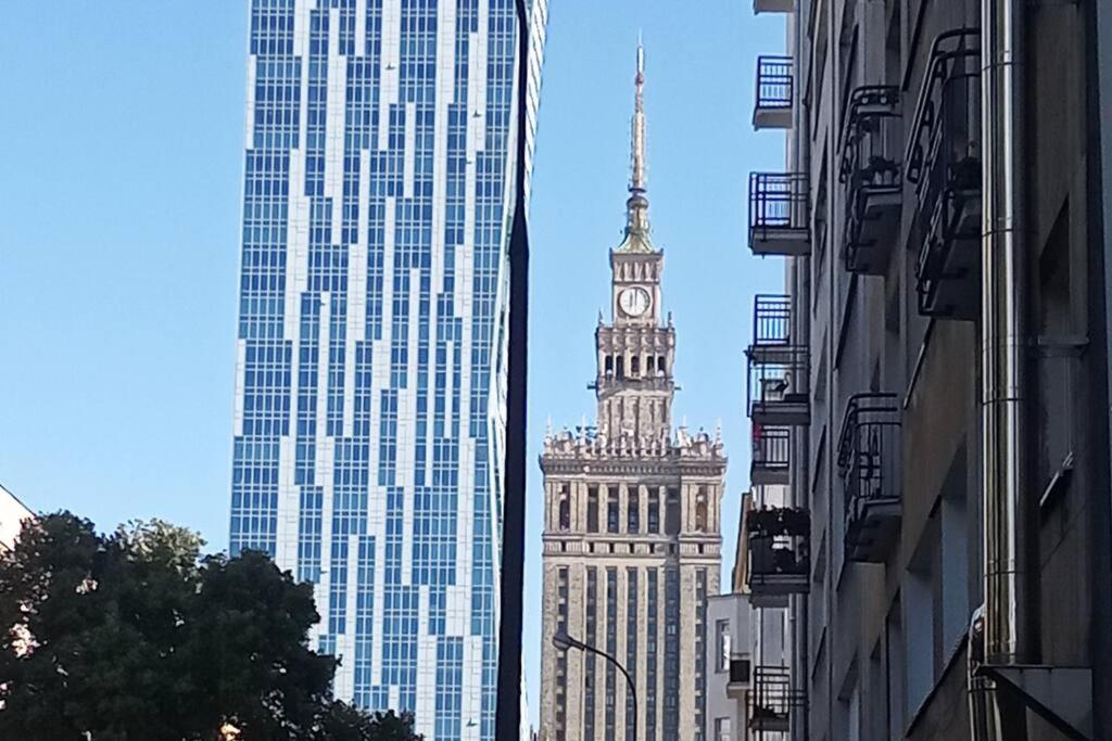a tall building with a clock tower in a city at City Center-Złota str. in Warsaw