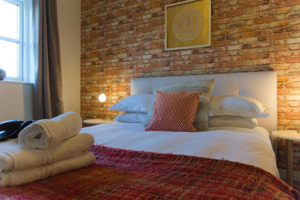 une chambre avec un grand lit avec un mur de briques dans l'établissement River View, à York
