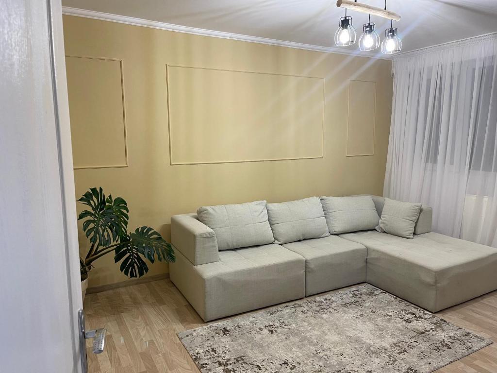 salon z białą kanapą i rośliną w obiekcie Home Comfort w Bukareszcie