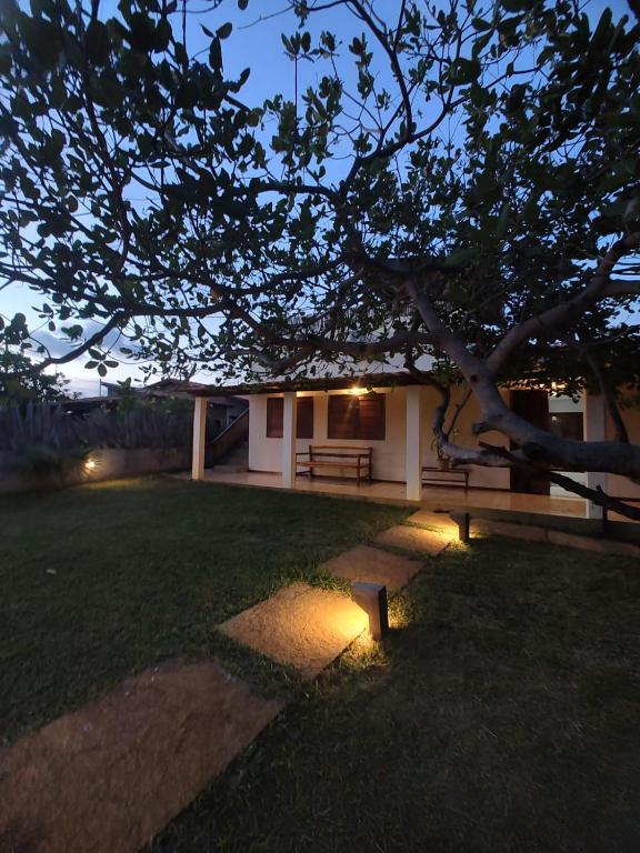 a house with a bench in a yard at night at Bons Aires in Atins