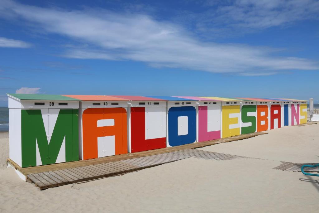a colorful building with the word miracles on the beach at L&#39;éclat balnéo in Malo-les-Bains