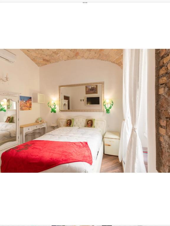 a bedroom with a white bed with a red blanket at Bretone XI b&b in Rome