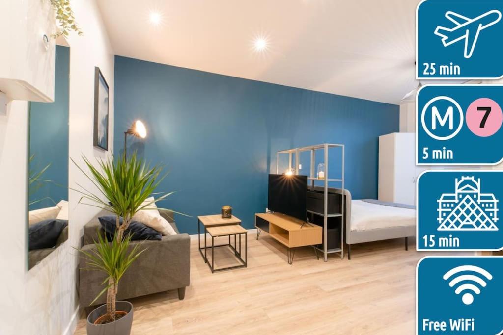 - une chambre dotée d'un mur bleu avec un lit et un canapé dans l'établissement Studio Cosy à 15min de Paris et 5min du Métro, à La Courneuve