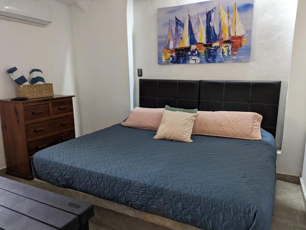 Apartamento Colibrí في اكستابا: غرفة نوم بسرير ودهان على الحائط