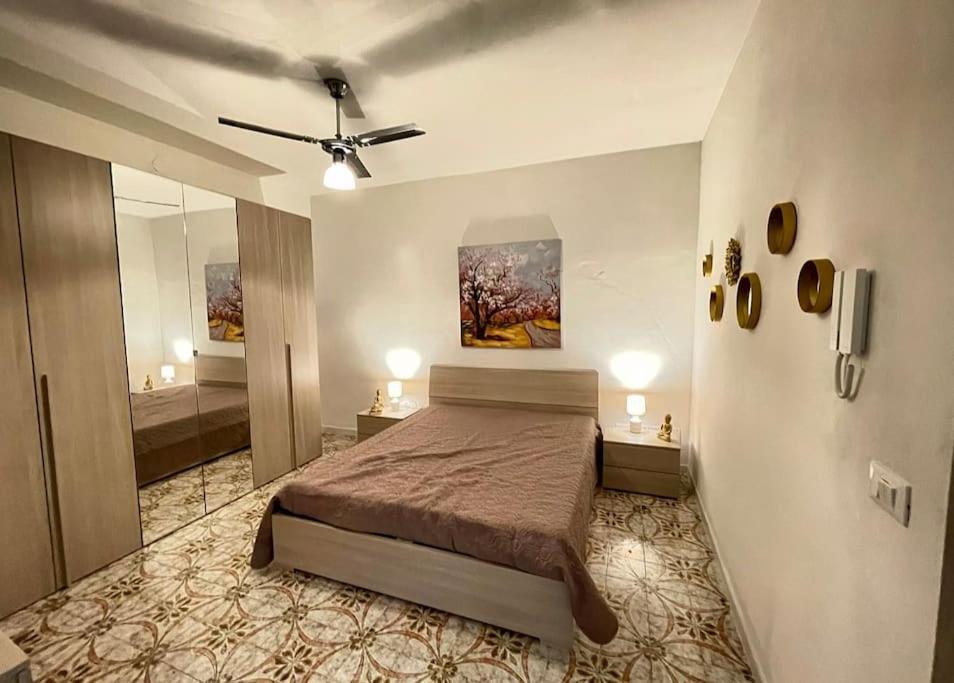 a bedroom with a bed and a bathroom with a mirror at Igea Suite in Noto