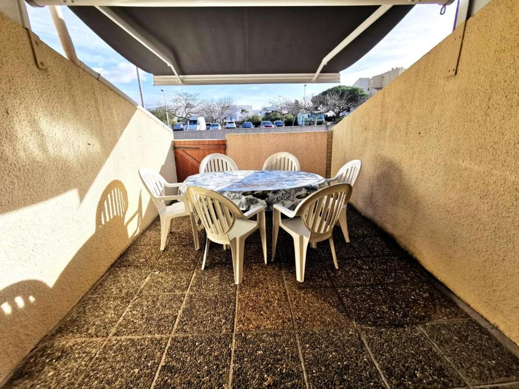 un patio avec une table et des chaises sur un balcon dans l'établissement Résidence Equateur - 2 Pièces pour 6 Personnes 781, à Leucate