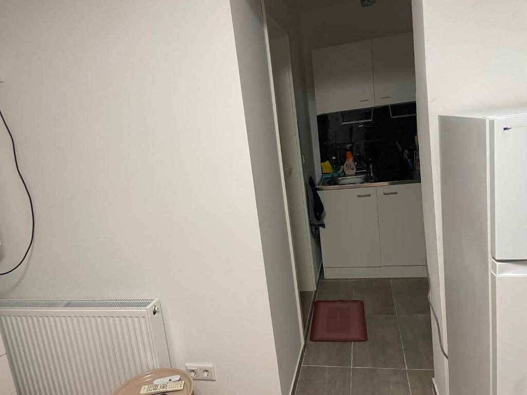 eine kleine Küche mit einem weißen Kühlschrank und Fliesenboden in der Unterkunft Ein Zimmer Wohnung für zwei Personen Monteure geeignet in Linsengericht