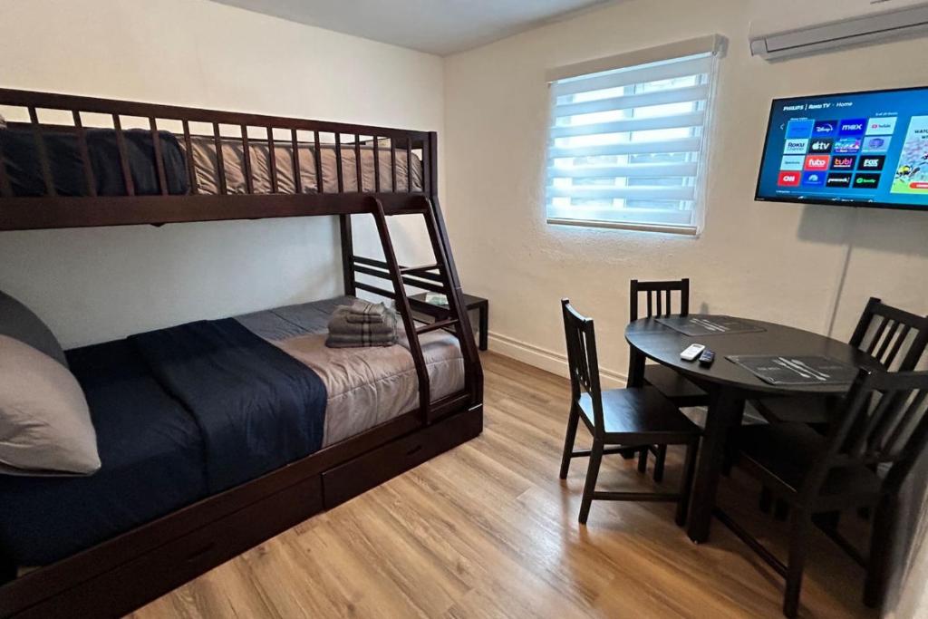 邁阿密的住宿－Peace Studio near Calle8 and Beaches，一间卧室配有一张双层床、一张桌子和一台电视。