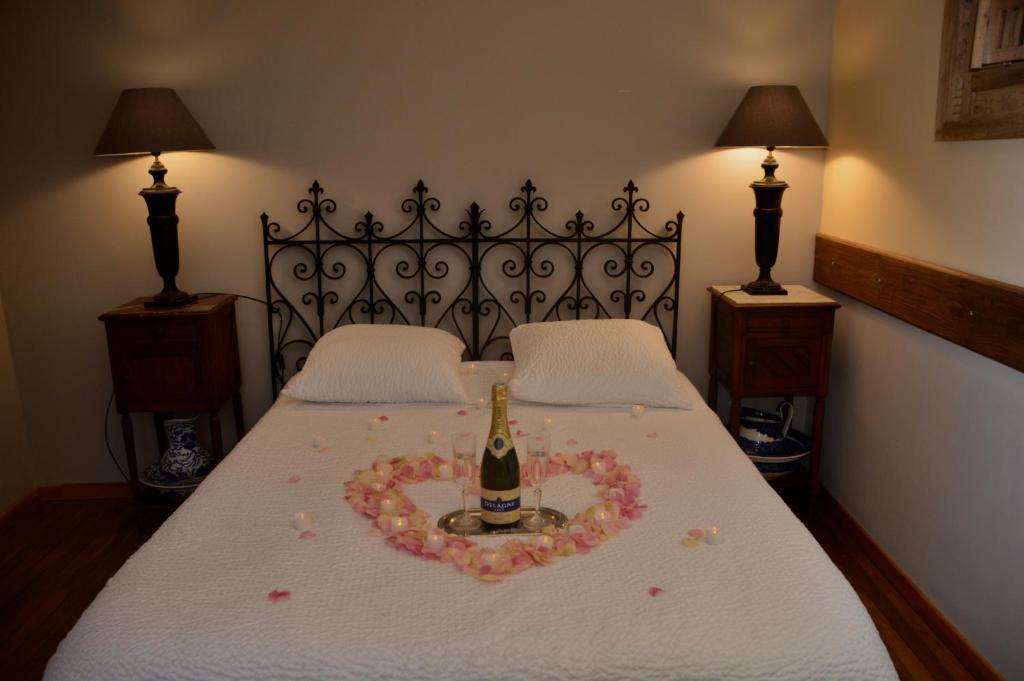 Un dormitorio con una cama con una botella de champán. en nuit romantique de retour de Chine, en Aubigny-sur-Nère