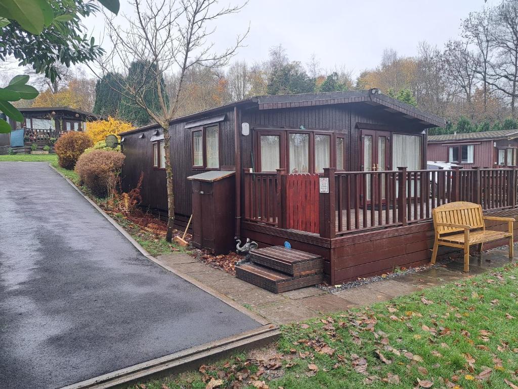 una piccola cabina con panchina sul lato del vialetto di Bunny Lodge 30 - Riverside a Builth Wells