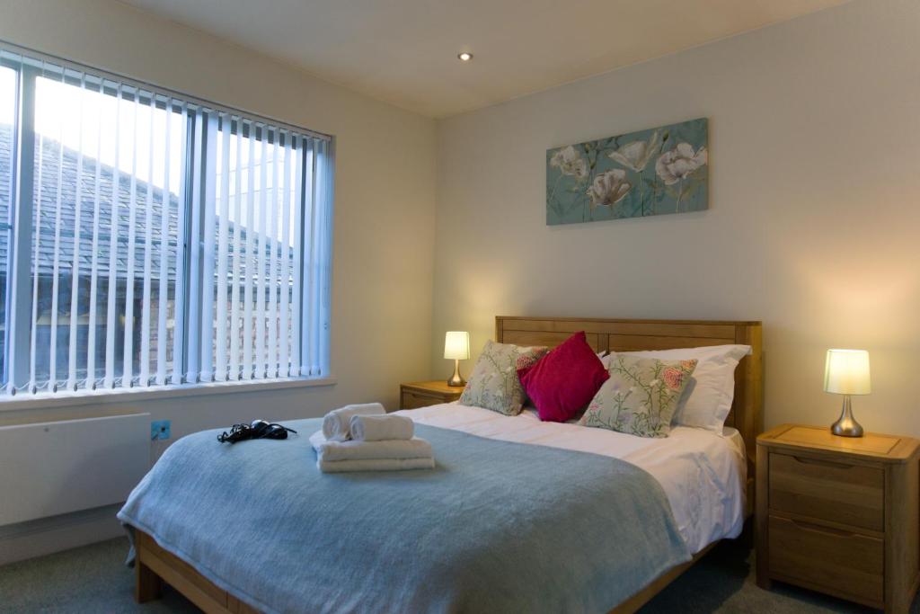 a bedroom with a bed with two lamps and a window at Almanna, Central York, only 6 minutes walk to York Minster in York