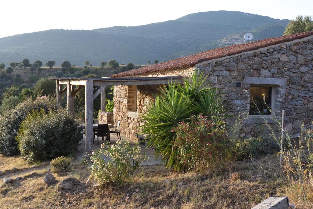 uma casa de pedra com uma mesa e uma cadeira no exterior em Casa Lysandra em Serra-di-Ferro