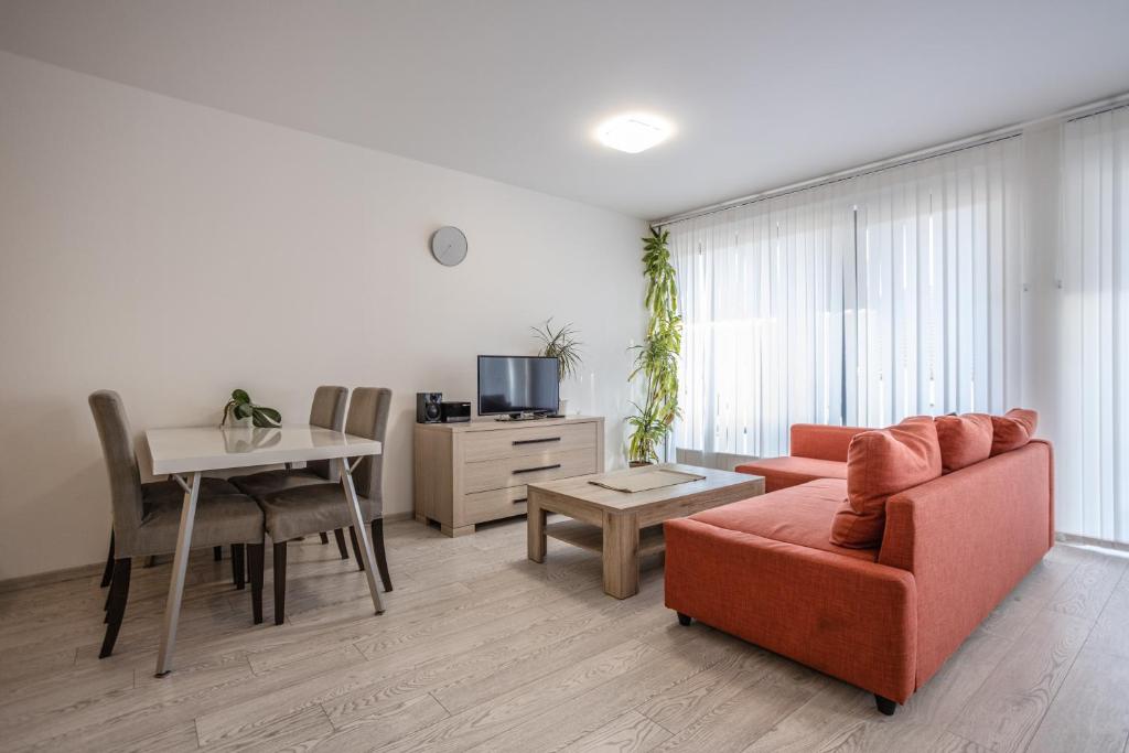 ein Wohnzimmer mit einem Sofa und einem Tisch in der Unterkunft Spacious Terrace Apartment with free private parking in Prag