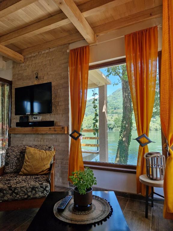 a living room with a couch and a large window at Beogradjanka mala in Zvornik