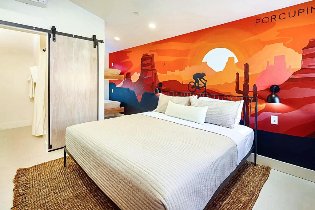 a bedroom with a bed with a painting on the wall at Downtown Kokopelli West 4 - Newly Remodeled Stylish Studio in Moab