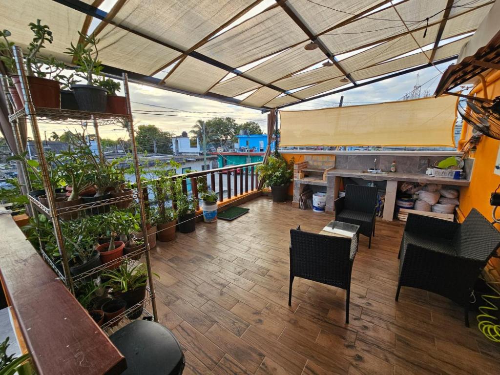 a balcony with plants and chairs and a fireplace at Habitación Cozumel in Cozumel