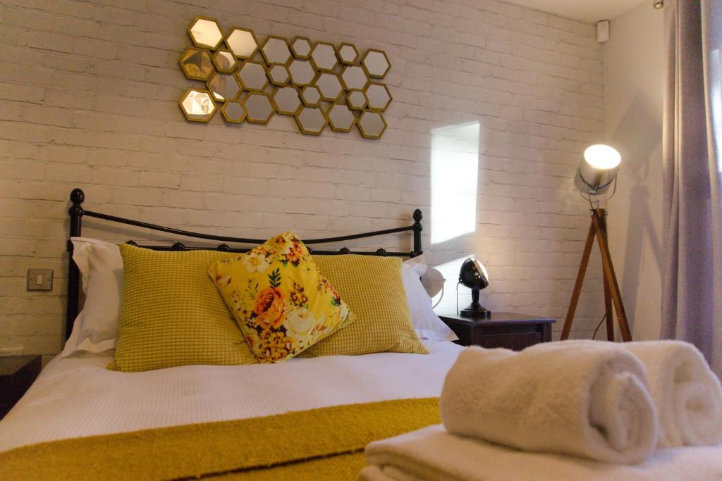 a bedroom with a bed with yellow pillows at Russet Quarter, Parking subject to availability in York