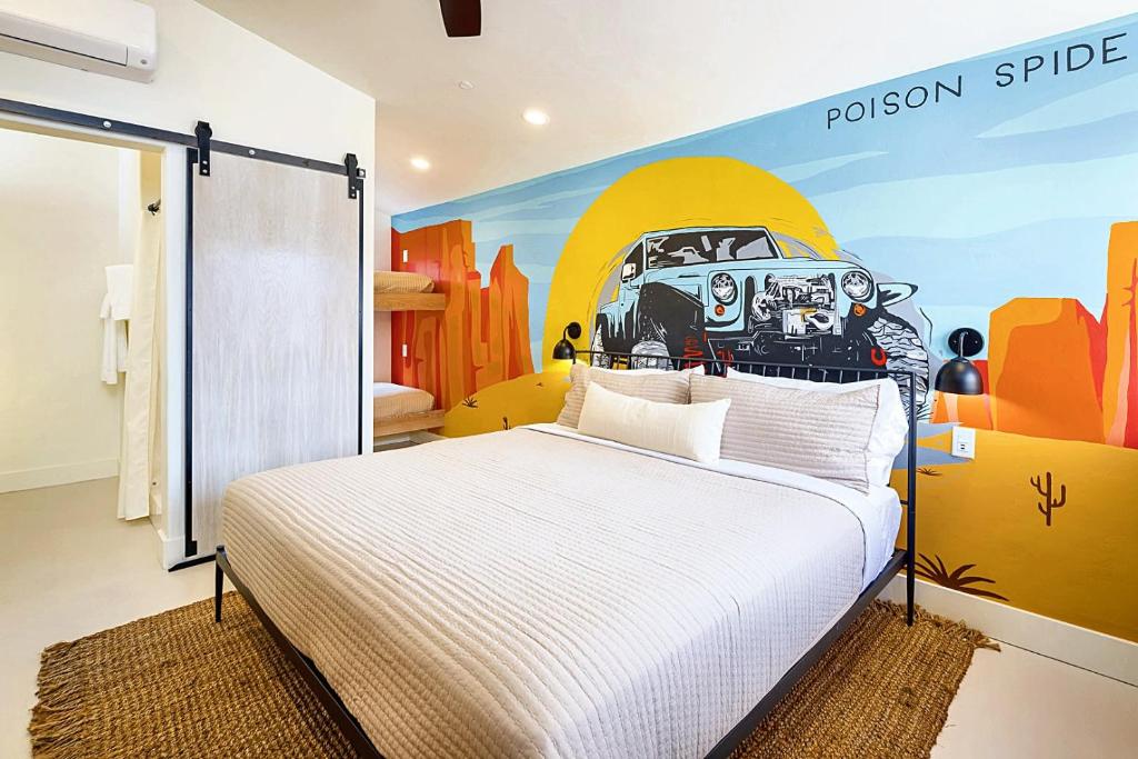 a bedroom with a bed with a painting on the wall at Downtown Kokopelli West 5 - Newly Remodeled Stylish Studio in Moab
