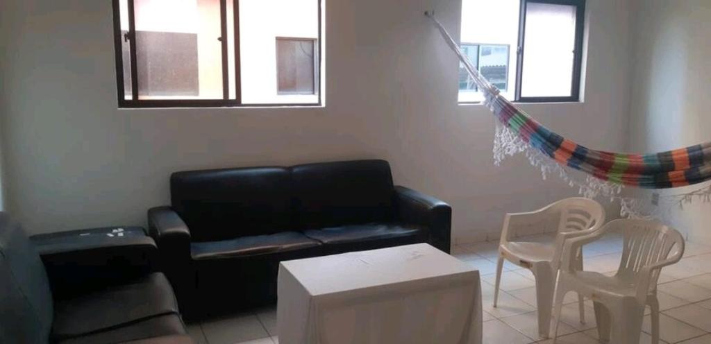 a living room with a couch and a table and chairs at Apartamento Mossoró in Mossoró