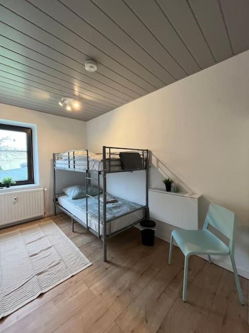 Zimmer mit 2 Etagenbetten und einem Stuhl in der Unterkunft Mikro Apartment Großenhain in Großenhain