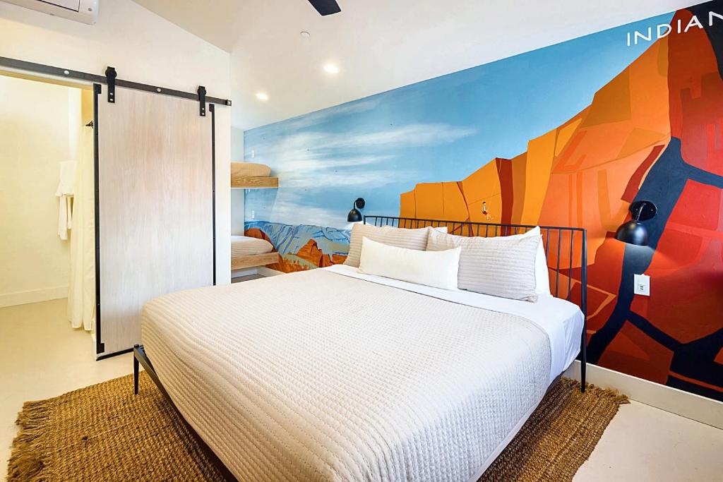 a bedroom with a bed with a painting on the wall at Downtown Kokopelli West 6 - Newly Remodeled Stylish Studio in Moab