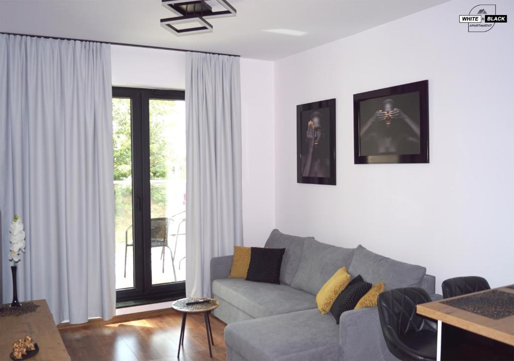 uma sala de estar com um sofá e uma mesa em White & Black Apartament em Ełk